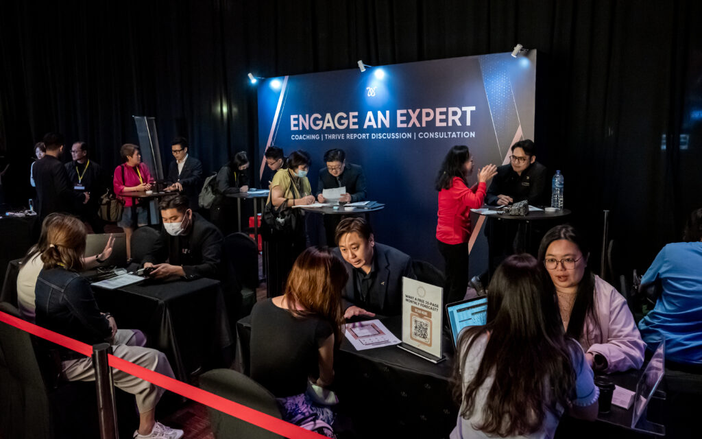 Clients receiving one-on-one BaZi consultations at Joey Yap's Engage An Expert consultation booth, with charts and reports on the table